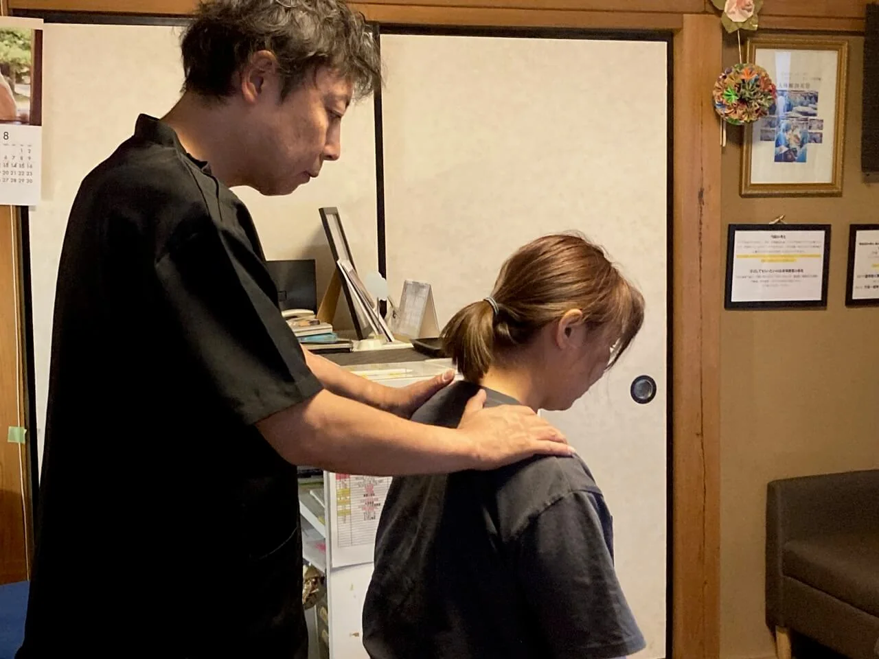 肩こりの施術で首から肩まわりの状態を確認している様子