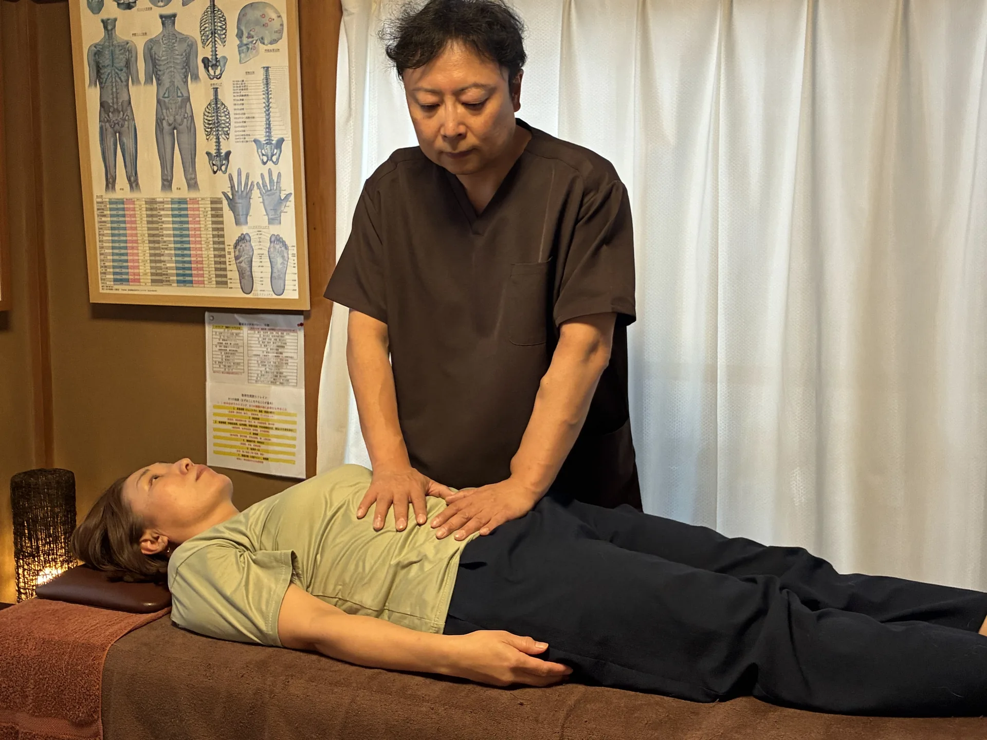内臓マニピュレーションで腹部に手を添えて組織の動きや張力を確認している様子